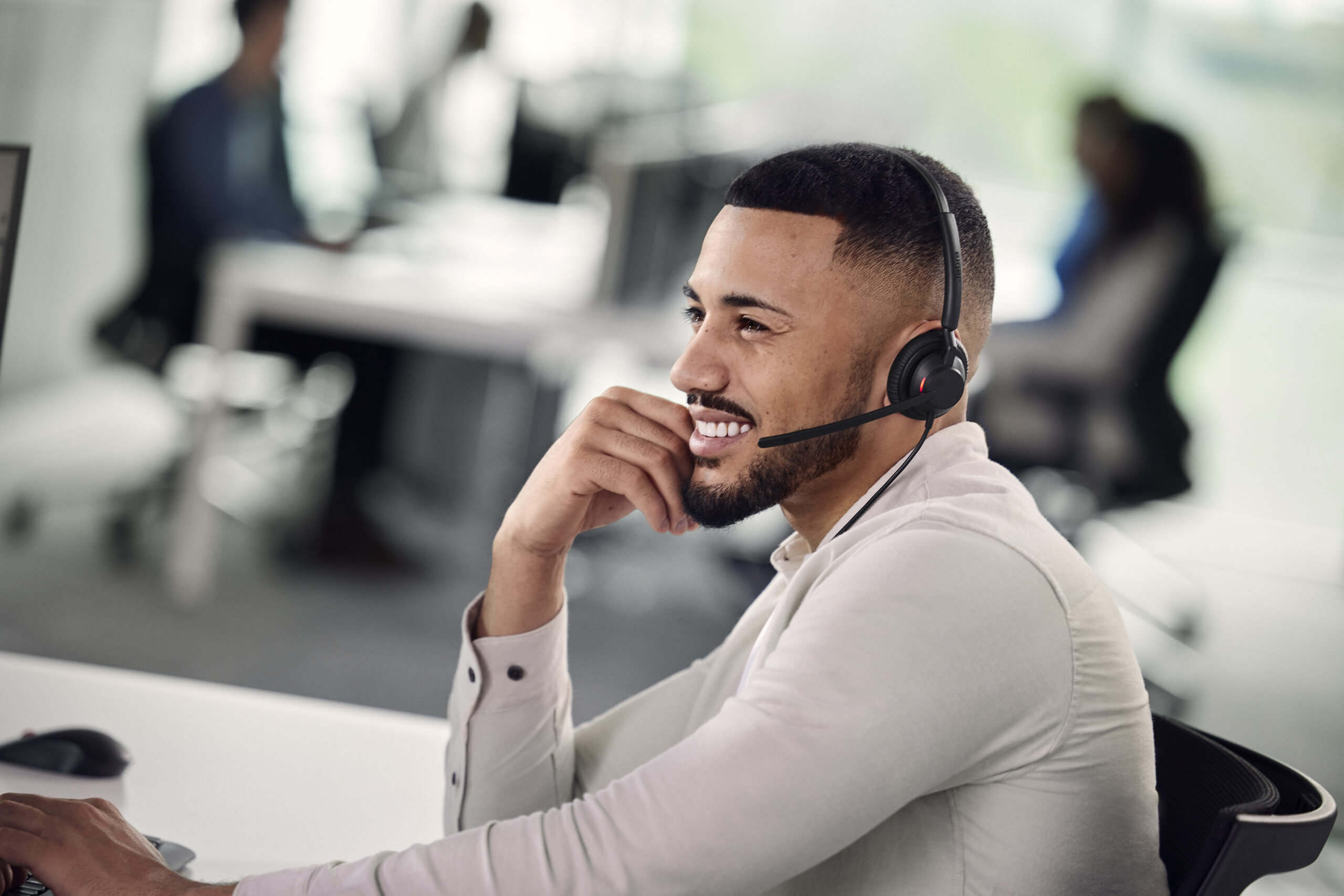 Ejecutivo joven utilizando el auricular Jabra Engage 40 en una oficina moderna